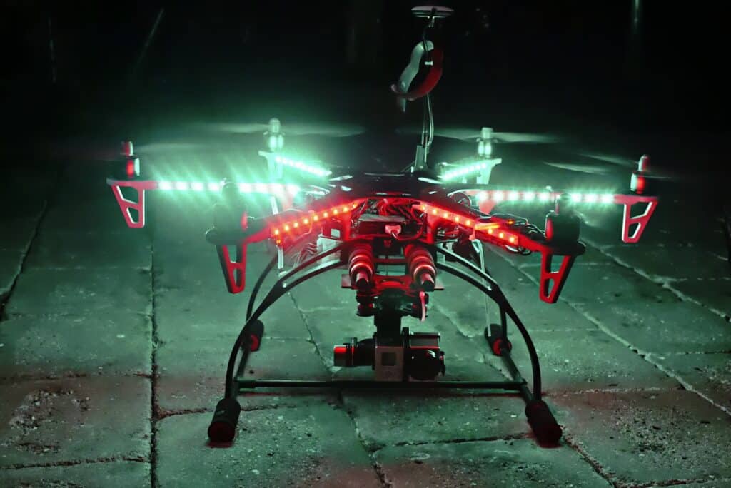 Silhouette of a drone flying against a dark night sky, public domain (CC0).